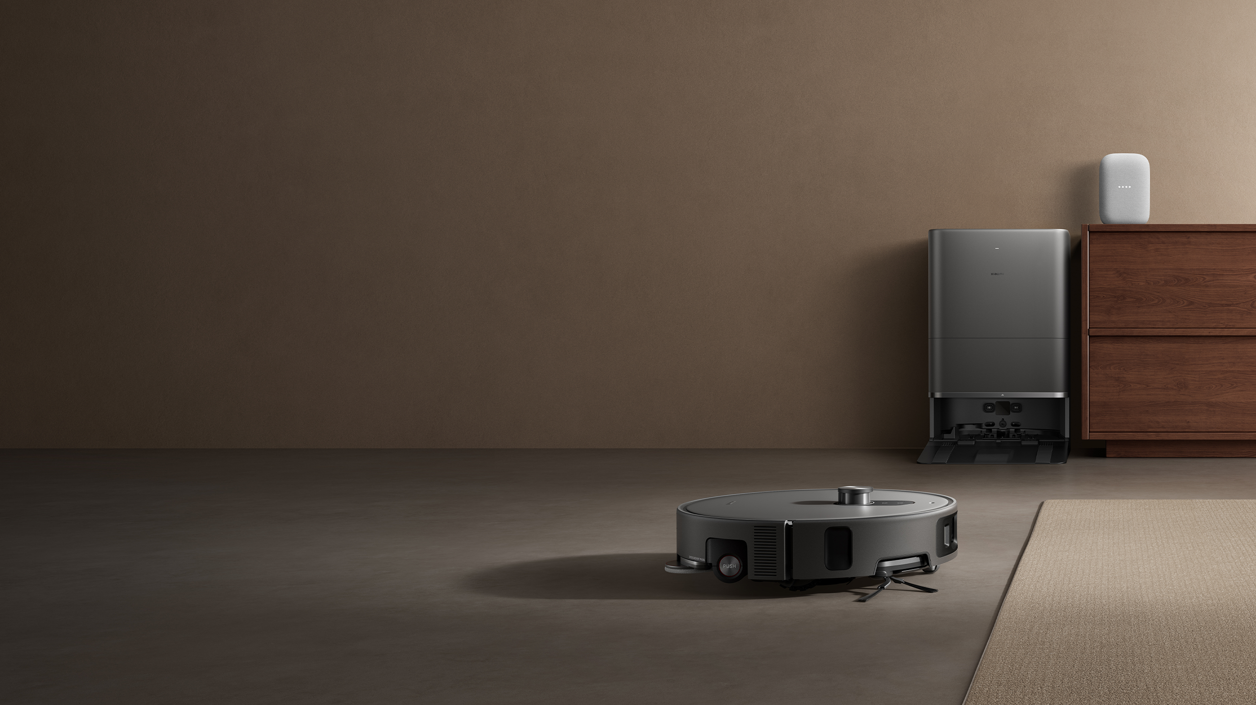 Le robot aspirateur Xiaomi Robot Vacuum 6 Max dans un salon, sa station contre le mur, visuel officiel Xiaomi